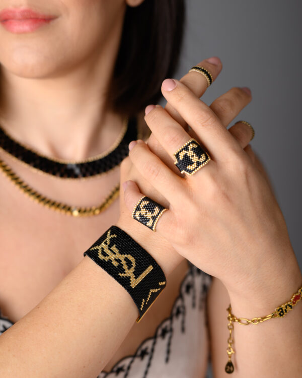 Model showcasing black and gold Miyuki Peyote-stitched rings and a loom-stitched bracelet by The Gem Stories.