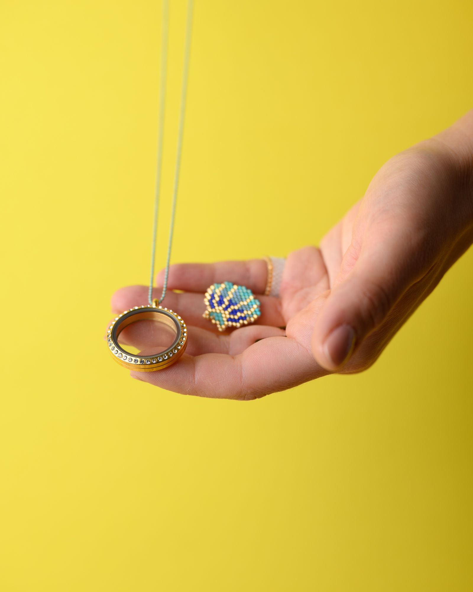 Miyuki Memory Locket by The Gem Stories, featuring a handmade beaded element using Peyote stitch, with an additional ring on a yellow background.