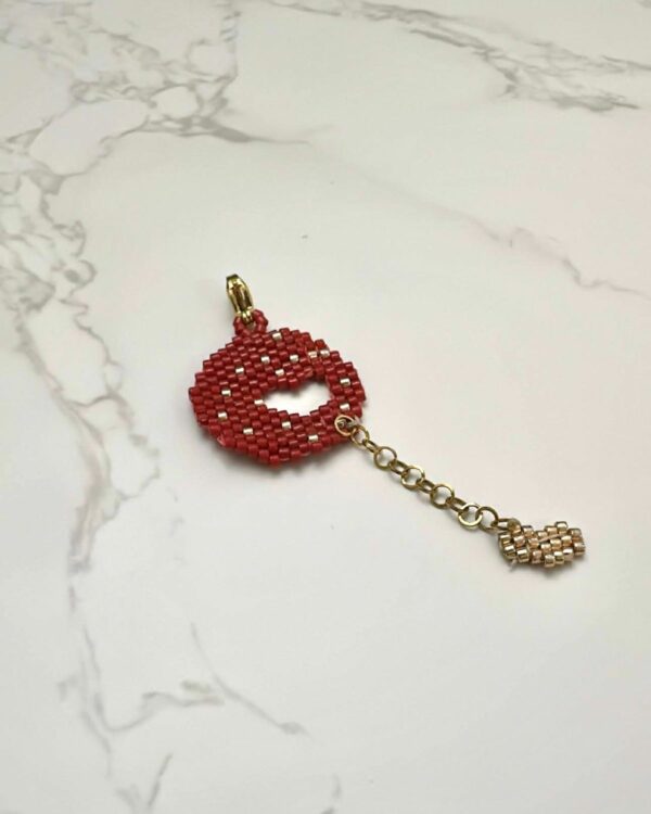 Miyuki beadwork perforated heart element in red with a dangling chain accent.