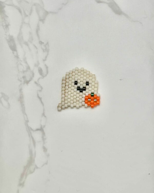 Miyuki beadwork ghost pendant holding a tiny pumpkin in orange and black details.