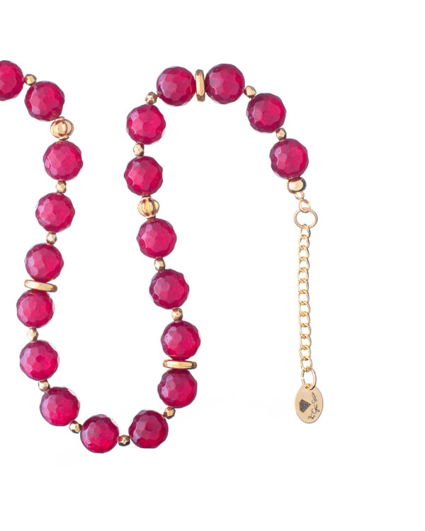 Close-up of a red jade necklace with gold accents and an extender chain