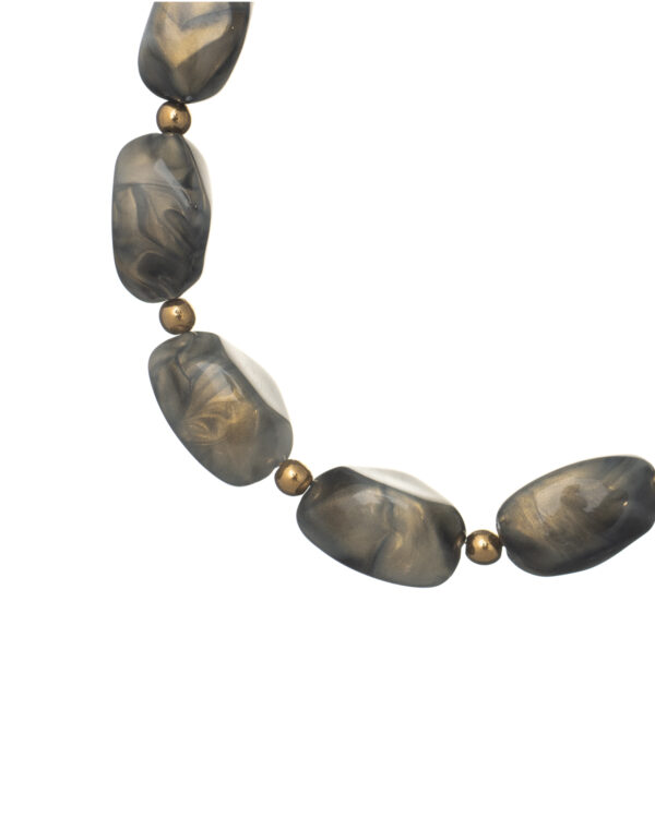 Close-up of grey shaded beads on a long necklace with gold accents