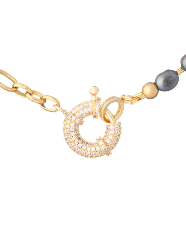 Gold chain necklace with black pearls and a circular clasp.