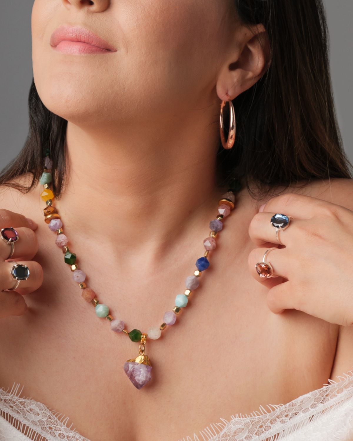 Colourful Jade Necklace with Amethyst Element Woman wearing a colourful jade necklace with an amethyst pendant