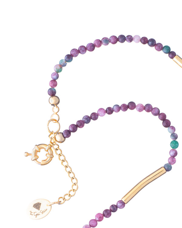 Close-up of a single-strand necklace with purple agate beads and gold accents