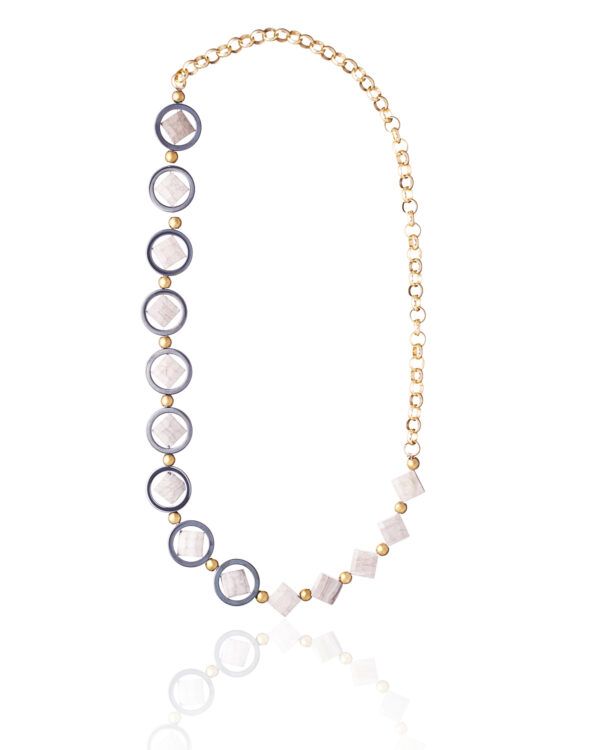 Black circles necklace with gold chain and white accents on a white background