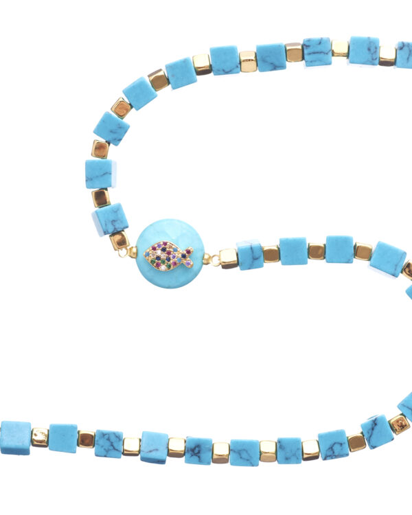 Close-up of turquoise cubes necklace with gold elements and central fish pendant on a white background