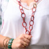 Woman holding a red chain necklace with a heart locket