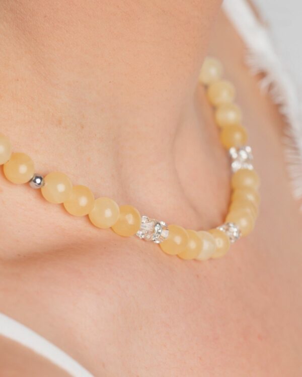 Close-up of an allover calcite necklace with crystal accents on a woman's neck