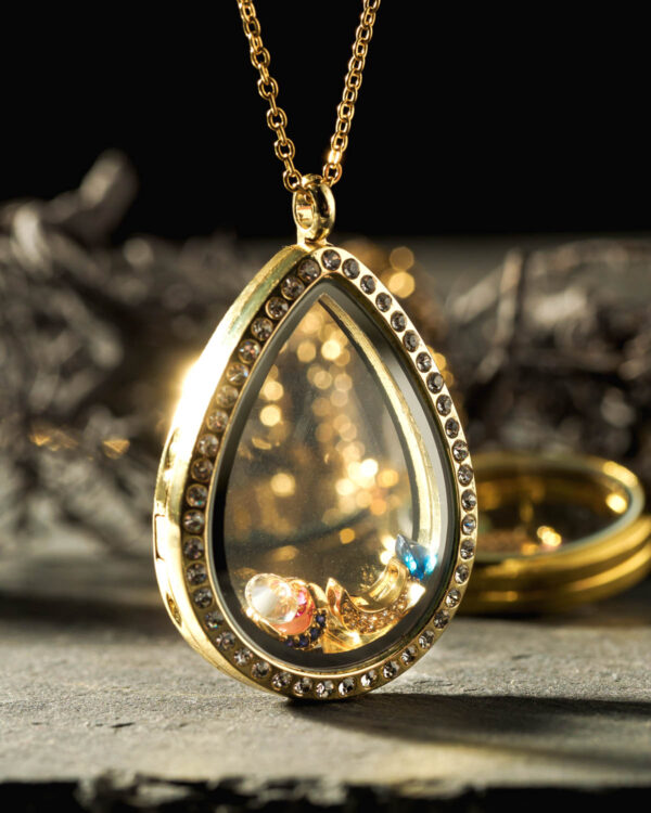 Close-up of a 35mm 24k gold plated teardrop floating memory locket with sparkling crystals and colorful charms
