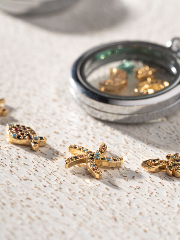 Close-up of a 25mm rhodium plated circular floating memory locket with gold charms