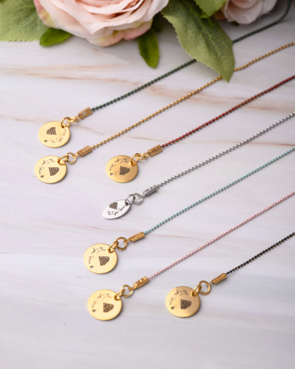 Collection of long chain necklaces with colorful dotted designs and unique pendants