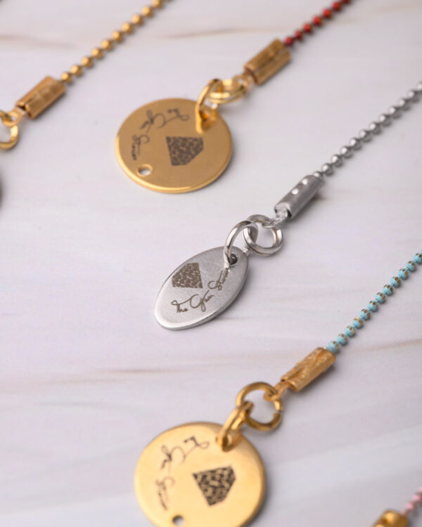 Collection of long chain necklaces with colorful dotted designs and unique pendants