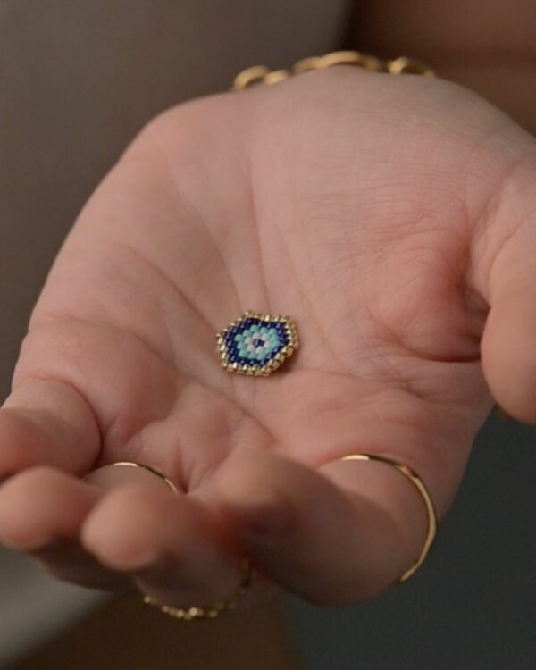 Close-up of a small, intricately beaded Protective Eye charm made with Miyuki beads