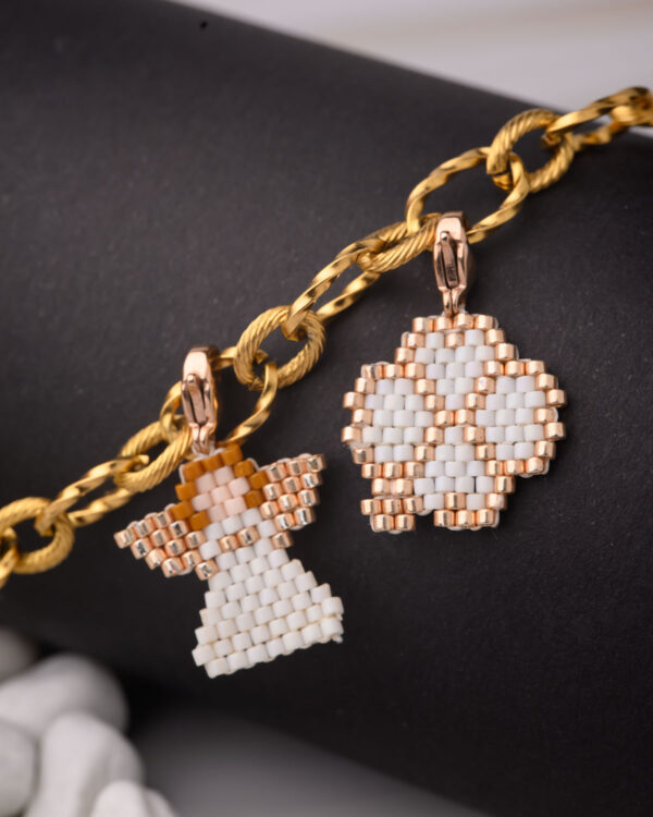 Miyuki Cuties Elements featuring a gold chain with white and gold angel and flower pendants made of beads.