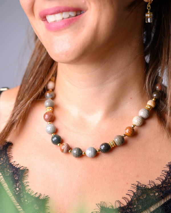 Woman wearing a Mookaite Jasper necklace with multicolored beads and gold accents