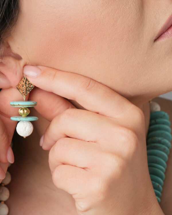 Turquoise and Lava Earring featuring turquoise discs, a gold bead, and a white lava stone.