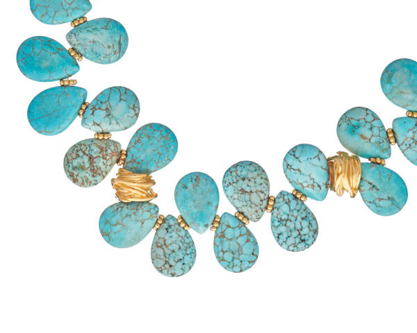 Necklace with turquoise drops and gold chain featuring blue turquoise stones.