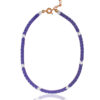 Close-up of a purple and white arrow hematite necklace with gold accents and a gold chain