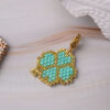 Close-up of a Miyuki Cuties Element Trefoil pendant with green beads and gold accents.