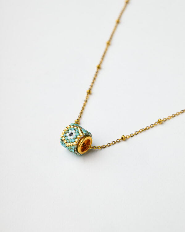 Gold chain necklace with a Miyuki beadwork round reel pendant by The Gem Stories.