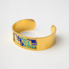 Mystique Waves Bangle Bracelet by The Gem Stories featuring intricate beadwork in blue and gold hues.
