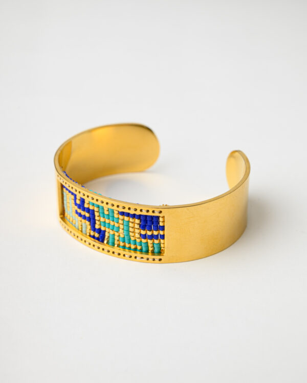 Mystique Waves Bangle Bracelet by The Gem Stories featuring intricate beadwork in blue and gold hues.