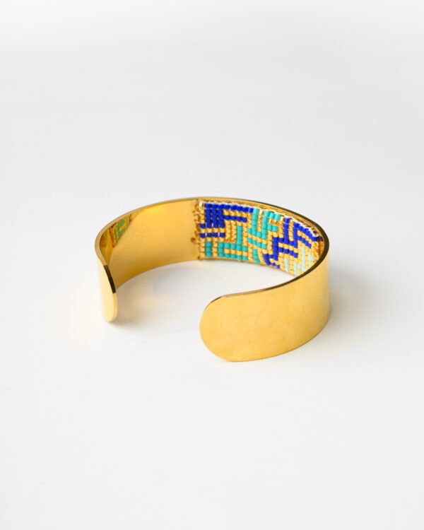 Handcrafted Mystique Waves Bangle Bracelet by The Gem Stories with blue and gold bead design.