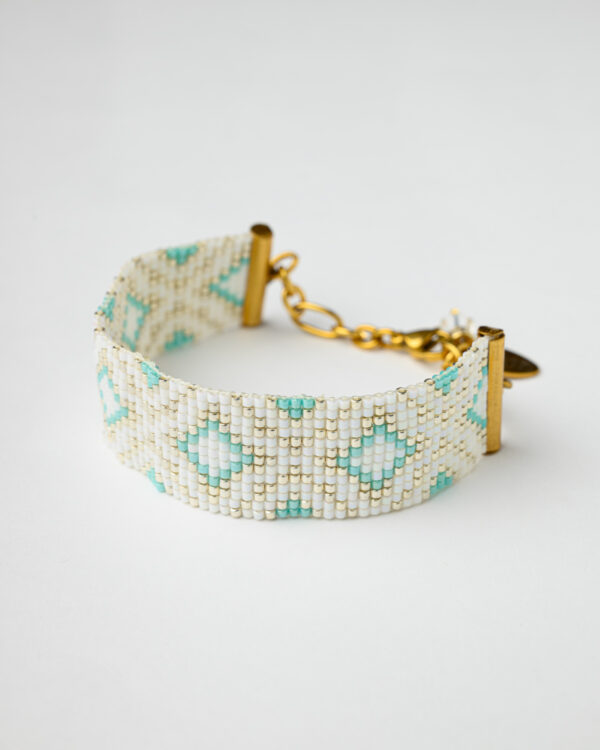Handcrafted Miyuki loom bracelet featuring white, turquoise, and gold beads in a geometric design with an adjustable gold-toned clasp.