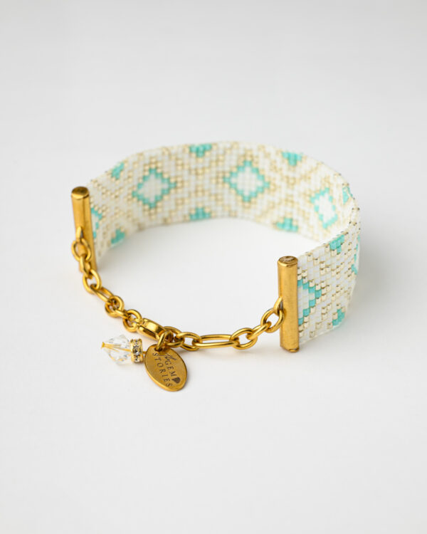 Handmade Miyuki bead bracelet in white, turquoise, and gold with a geometric pattern and adjustable gold clasp.
