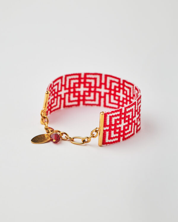 Intricate loom-stitched bracelet with Miyuki beads in red and white geometric design.