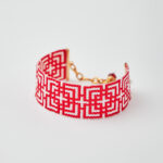 Handmade Miyuki loom-stitched bracelet with red and white geometric maze design.