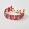 Handmade Miyuki loom-stitched bracelet with red, blue, and gold striped design.