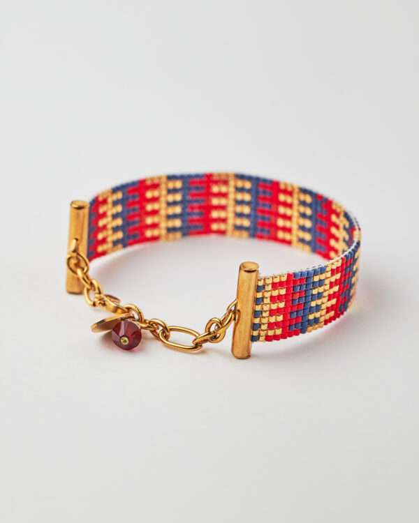 Intricate loom-stitched bracelet with Miyuki beads in red, blue, and gold striped design.