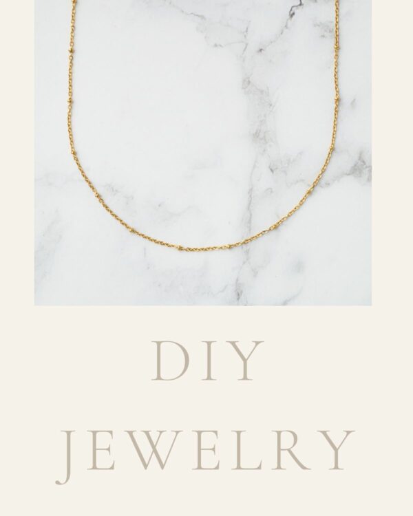 Long chain necklace with petite dots in 24k gold on marble background