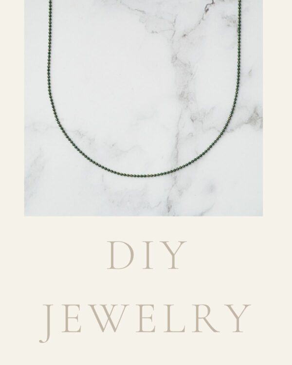 Long chain necklace featuring elegant dark green dots, showcasing a sophisticated and contemporary design.