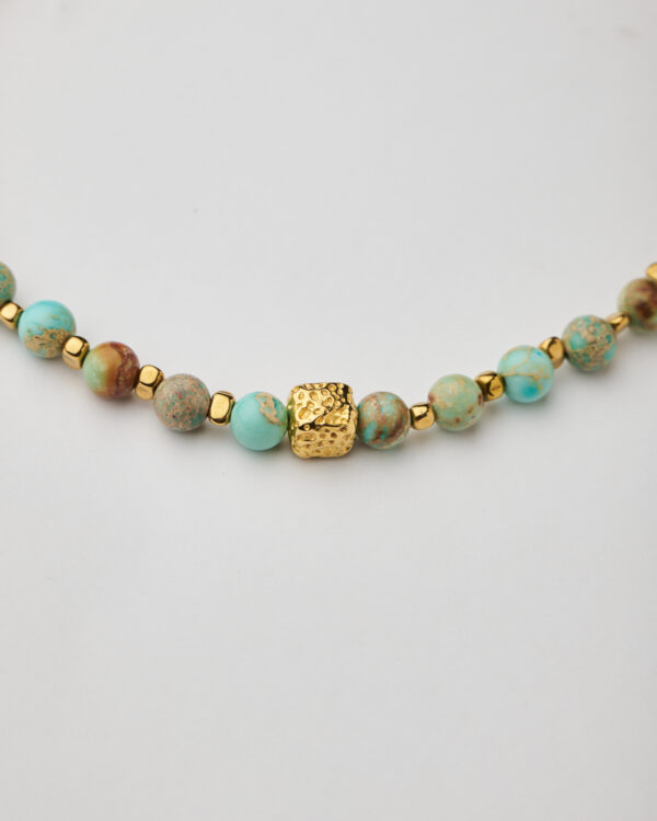 Close-up of handmade turquoise and gold cube necklace by The Gem Stories