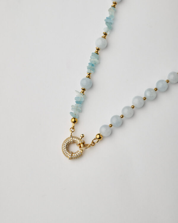 Close-up of handmade aquamarine necklace with gold toggle clasp and zircon crystals