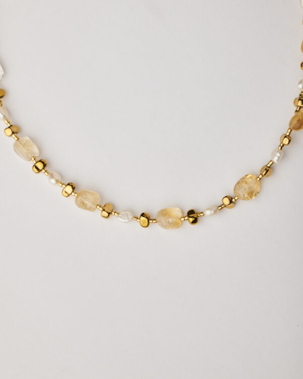 Close-up of handmade citrine and pearl necklace with gold plated details