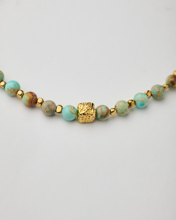 Close-up of handmade turquoise and gold cube necklace by The Gem Stories