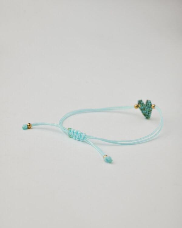Close-up of heart-shaped miyuki beaded bracelet with aqua macrame cord