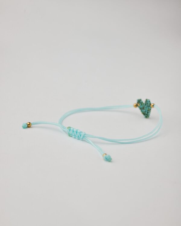 Close-up of heart-shaped miyuki beaded bracelet with aqua macrame cord