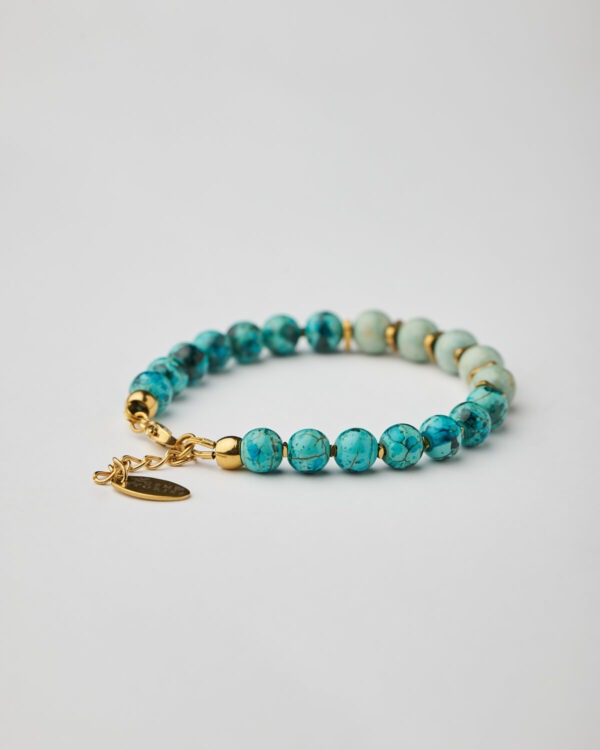Close-up of bracelet with marble aquamarine howlite in two tones and gold clasp