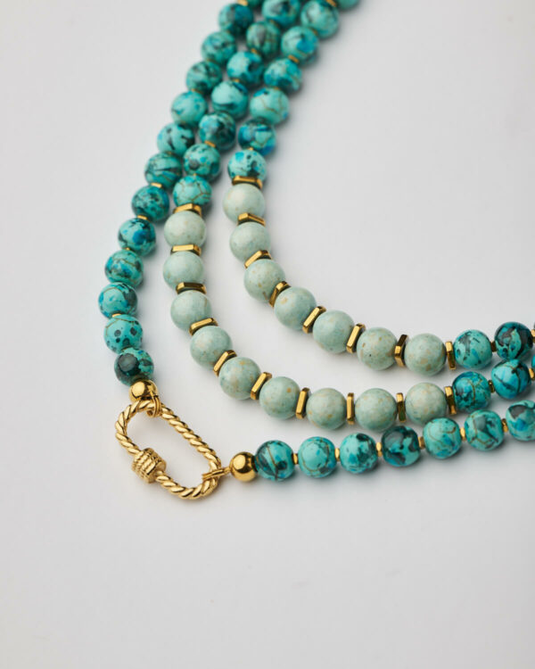 Close-up of marble aquamarine howlite necklace with twisted gold clasp