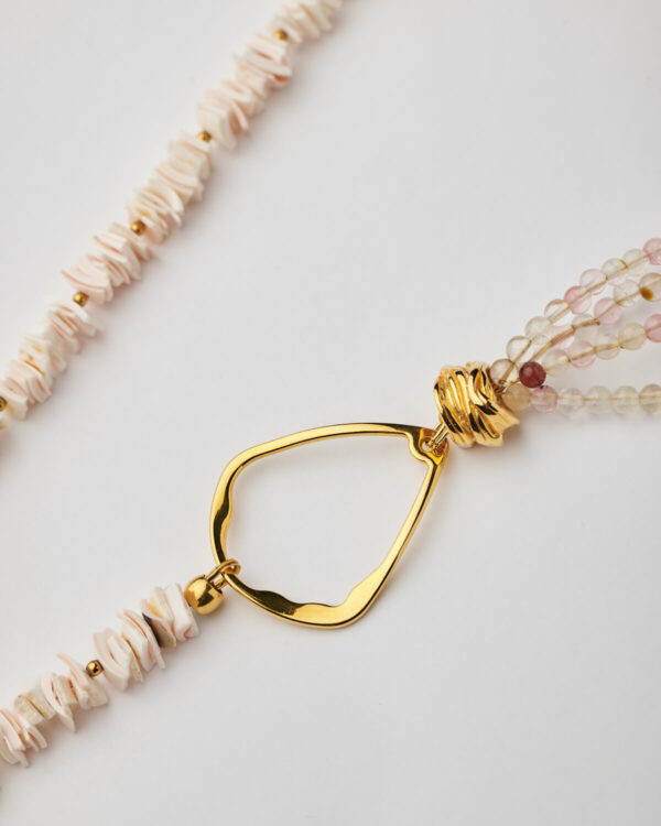 Close-up of abstract golden connector and multistrand gemstone beading