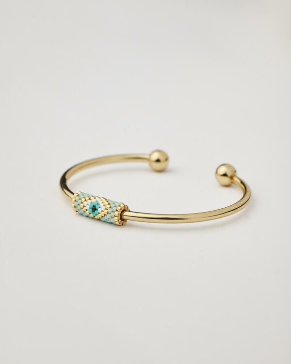Front view of gold cuff bracelet with woven miyuki evil eye design