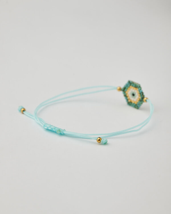 Close-up of turquoise and gold miyuki bracelet with adjustable macrame cord
