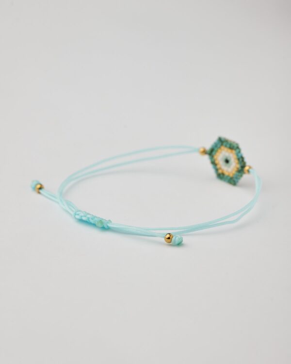 Close-up of turquoise and gold miyuki bracelet with adjustable macrame cord