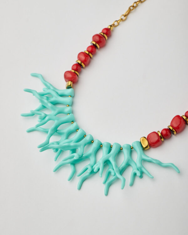 Close-up of turquoise coral elements and red ceramic beads in handmade necklace