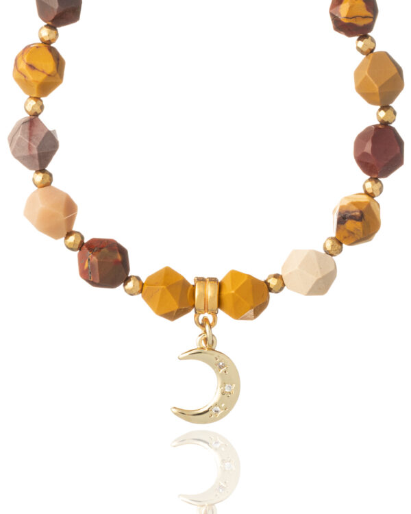 Close-up of gold moon charm and faceted jade beads